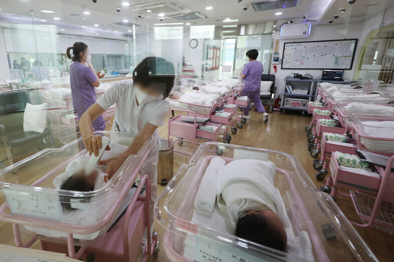 Nurses and other health professionals look after newborns in the maternity ward of a postpartum care facility in Seoul in February. (Yonhap)