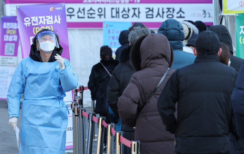 People wait to be tested for COVID-19 at a temporary screening station outside Seoul Station on Sunday. (Yonhap News)