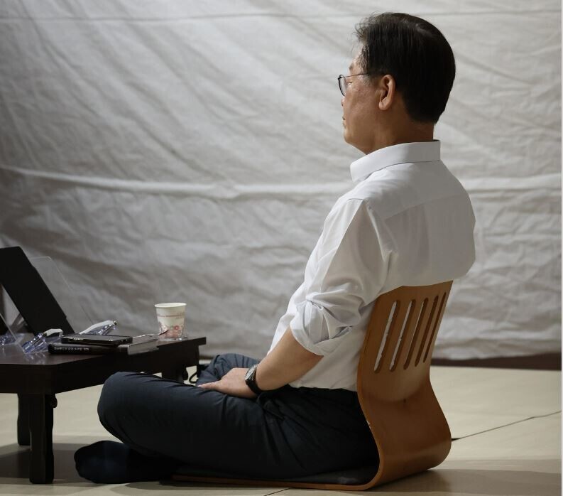 Lee Jae-myung, the leader of the Democratic Party, sits in a tent outside the National Assembly building in Yeouido, Seoul, as he carries out a hunger strike in protest of the Yoon Suk-yeol administration on Aug. 31. (Kim Bong-gyu/The Hankyoreh)