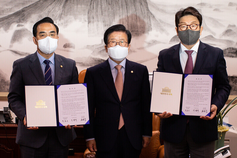 National Assembly Speaker Park Byeong-seug (center) stands with Democratic Party floor leader Park Hong-keun (left) and People Power Party floor leader Kweon Seong-dong (right) after reaching a compromise on prosecution reform legislation on April 22, 2022. (pool photo)