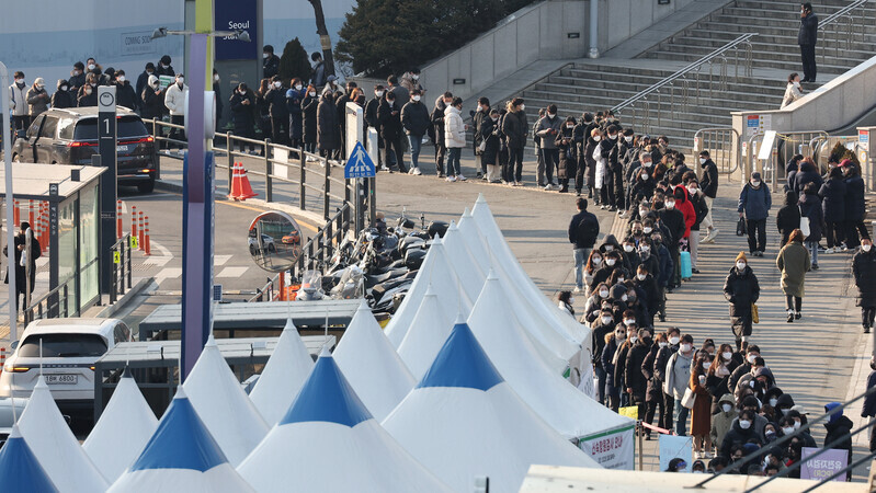 A long line of people winds out of a temporary COVID-19 screening station at Seoul Station on Monday morning. (Yonhap News)