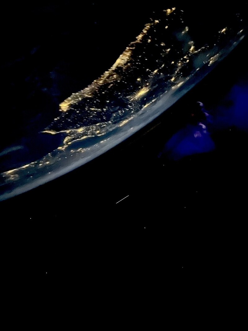 시안 프록터가 우주여행 중 찍은 지구의 밤. 흰줄무늬는 위성의 이동 궤적이며, 오른쪽 푸른색 얼룩은 유리에 빛이 반사돼 생긴 것이다. 시안 프록터 트위터