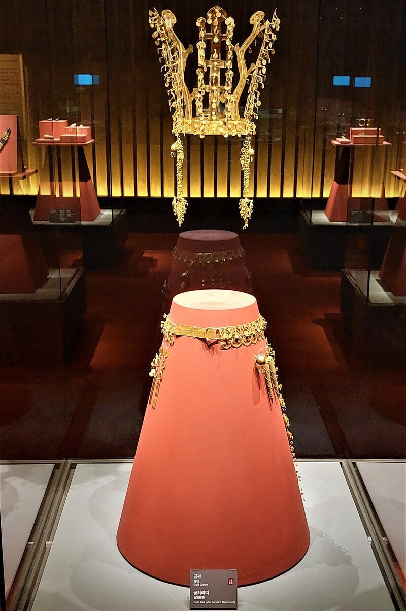 The gold crown and belt are displayed as they would appear on a child of about 1 meter (3.3 ft).