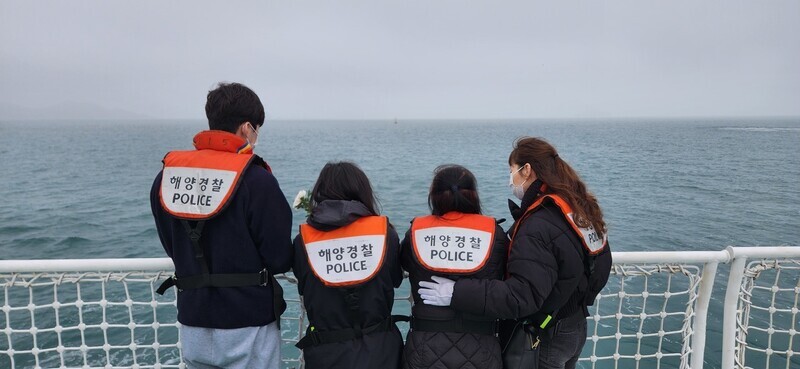 Families who lost loved ones in the tragic sinking of the Sewol ferry 10 years ago throw white carnations into the sea near where the ferry sank to mark the anniversary of the disaster on April 16, 2024. (Kim Yong-hee/The Hankyoreh)
