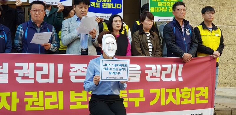 Workers demand the right to sit down during work hours in front of the main branch of Lotte Department Store in Seoul on Oct. 2. (Jung Hwan-bong