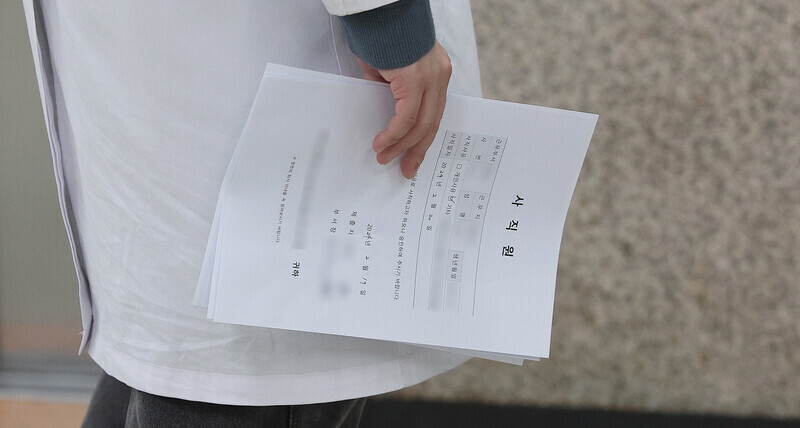 A resident at a university hospital in Daegu holds a resignation letter on Feb. 19. (Yonhap)
