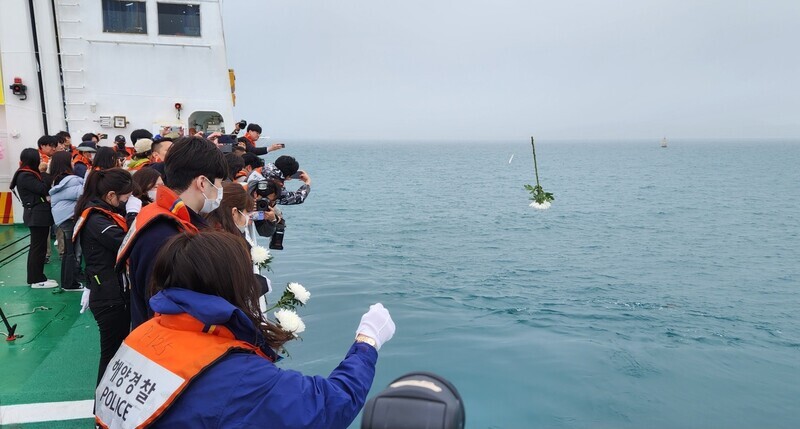 Families who lost loved ones in the tragic sinking of the Sewol ferry 10 years ago throw white carnations into the sea near where the ferry sank to mark the anniversary of the disaster on April 16, 2024. (Kim Yong-hee/The Hankyoreh)