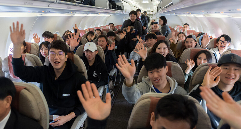 South Korean alpine and cross country skiers wave as they prepare to depart from Yangyang International Airport in Gangwon Province for a two-day