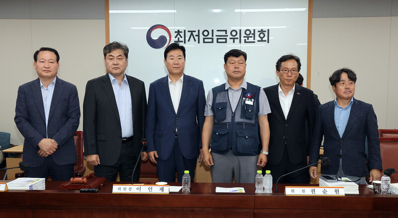 지난 10일 정부세종청사에서 열린 제12차 최저임금위원회 전원회의에서 내년 최저임금을 시간당 1만320원으로 결정한 공익위원-사용자위원-근로자위원들이 기념 촬영을 하고 있다. 연합뉴스