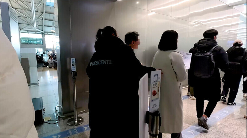 Amirkulova Kulkar, third from the left, a former student at Hanshin University’s Korean language academy, walks with other Uzbek students through Incheon International Airport on Nov. 27 after being rounded up by school staff and security escorts. (still from video provided by Hanshin University)
