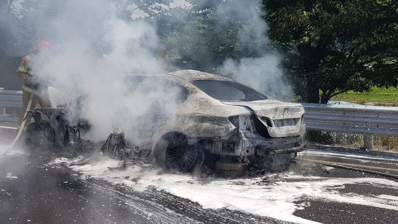 Firefighters extinguish a fire after a BMW 520d model burst into flames on the Yeongdong Expressway near Wonju