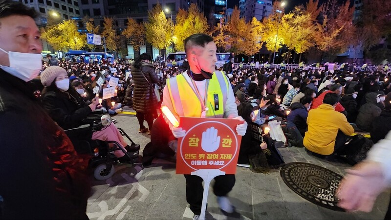 5일 저녁 7시께 촛불행동 집회에 참여한 자원봉사자들이 안전을 위해 집회 참가자들을 통제하고 있다. 박지영 기자