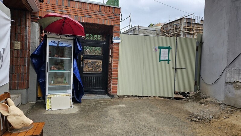 An industrial refrigerator with three pig heads in it and a mask of a pig head sit outside the construction site for a mosque in Daegu’s Daehyeon neighborhood on April 25. (Kim Gyu-hyeon/The Hankyoreh)