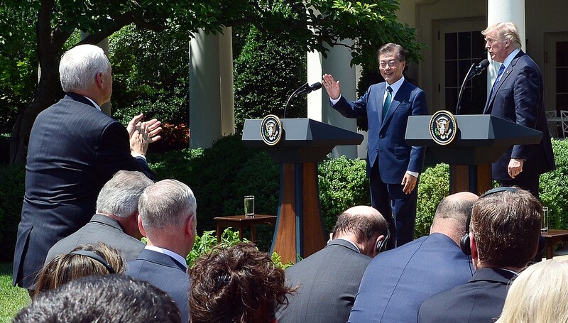 US Vice President Mike Pence stands and applauds as President Moon Jae-in and US President Donald Trump hold a press conference in the White House Rose Garden after their expanded summit in Washington DC