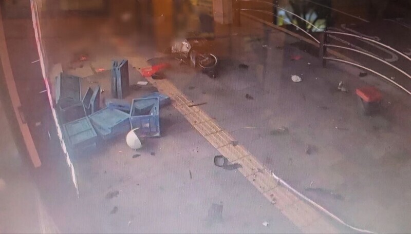 A frame from a nearby store's surveillance footage showing the immediate effects of a car collision. (courtesy of the reader)