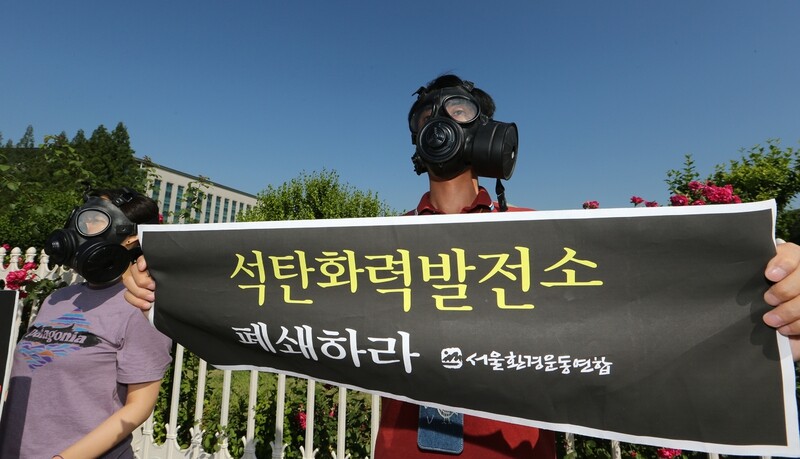 An activist from the Seoul branch of Korean Federation for Environmental Movement wears a gas mask in front of the National Assembly in Seoul calling for the deletion of the clause including clean diesel cars in the Environmentally Friendly Automobile Law