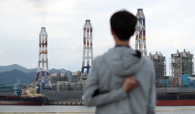 One resident stands in front of the Samcheonpo 1 and 2 coal-fired power plants (far left) in Goseong