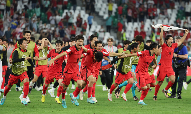 Players for Korea’s national football team rush onto the field to celebrate their victory over Portugal in their third match of the Group H playoffs at Education City Stadium in Al Rayyan, Qatar, on Dec. 3 (KST). (Yonhap)