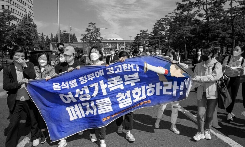 Participants in a joint action to block the abolition of the MOGEF attempt a surprise press conference outside the inauguration of Yoon Suk-yeol at the National Assembly on May 10. Their sign reads, “A warning to the Yoon Suk-yeol administration: Retract the abolition of the MOGEF!” (Kim Jin-su/The Hankyoreh)