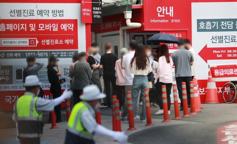 People wait in line at a hospital in Seoul to get tested for COVID-19 on Monday. (Yonhap News)