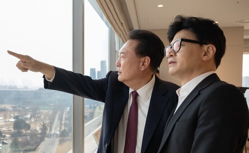 President Yoon Suk-yeol and People Power Party interim leader Han Dong-hoon speak while gazing out the window of the presidential office in Yongsan on Jan. 29, 2024, during a meeting between the president and the leadership of the ruling party. (courtesy of the presidential office)