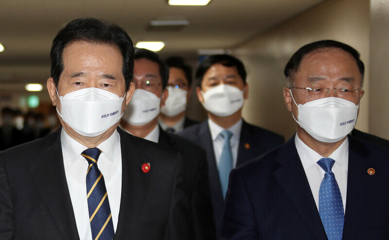 Prime Minister Chung Sye-kyun, left, and Deputy Prime Minister and Minister of Economy and Finance Hong Nam-ki enter a briefing room Monday to announce the government's anti-real estate speculation measures at the Seoul Government Complex. (Yonhap News)
