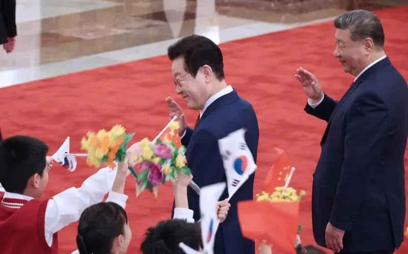 President Lee Jae Myung of South Korea and President Xi Jinping of China wave to children at a ceremony welcoming Lee to Beijing’s Great Hall of the People on Jan. 5, 2026. (Yonhap)
