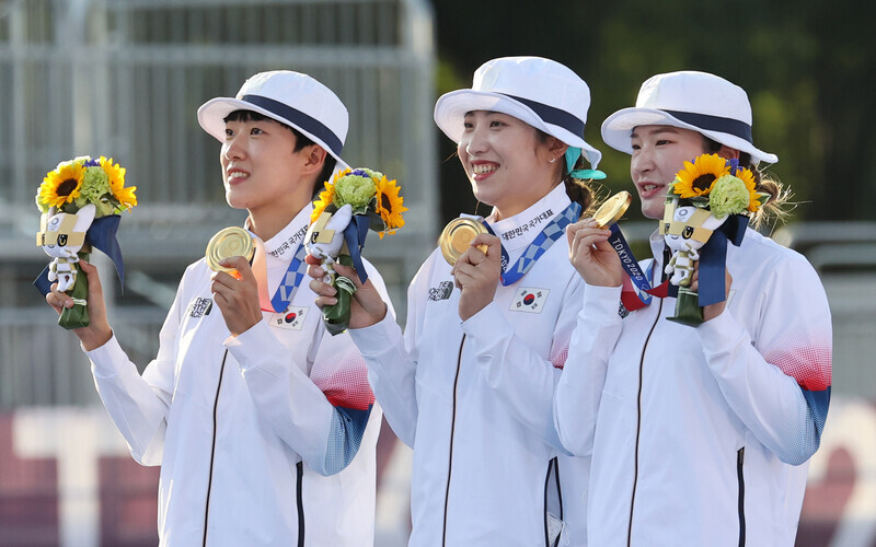 An San (left), Jang Min-hee (center) and Kang Chae-young of the Korean women’s archery team pose for a photo with their gold medals for the women’s team event at the Tokyo Olympics on Sunday at the Yumenoshima Park Archery Field in Tokyo. (pool photo)