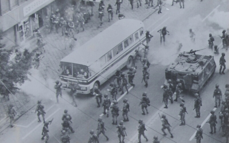 During the May 18 Democratization Movement, martial law soldiers are using tracked armored vehicles to arrest citizens on buses.  Capture of the Defense Security Command photo album