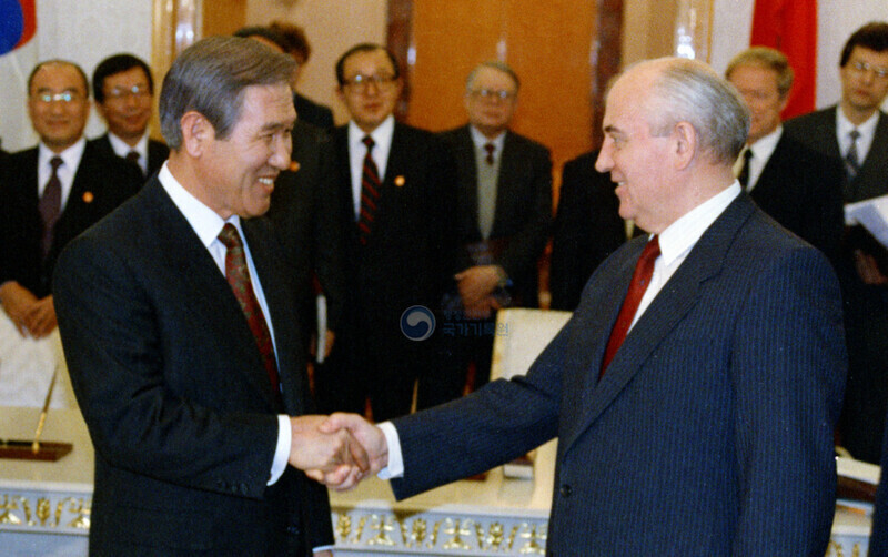 While visiting the Soviet Union, then-South Korean President Roh Tae-woo shakes hands with Soviet President Mikhail Gorbachev after a summit on Dec. 14, 1990. (provided by the National Archives of Korea)