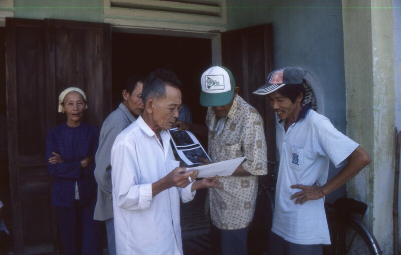 2001년 3월 베트남 퐁니·퐁녓 마을 주민들이 <한겨레21>에 보도된 베트남전 당시 민간인 피학살자 사진을 돌려보며 가족이나 지인이 있는지 확인하고 있다. 고경태