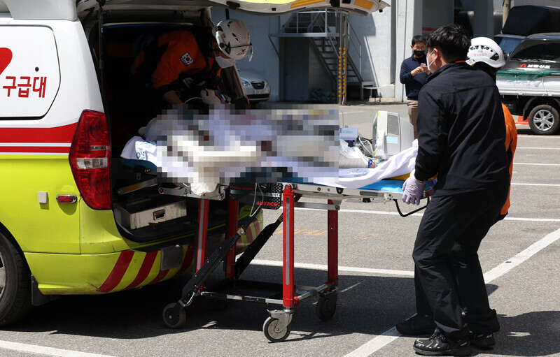 A union leader surnamed Yang is loaded into an ambulance outside the Gangneung branch of the Chuncheon District Court on May 1 after self-immolating ahead of a warrant review hearing. (Yoon Woon-sik/The Hankyoreh)