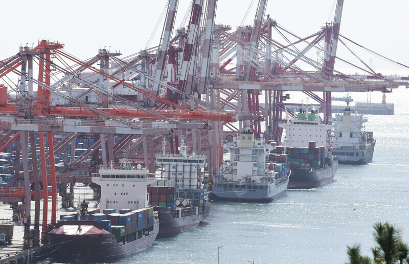Containers are loaded and unloaded from ships at a port in Busan. (Yonhap)