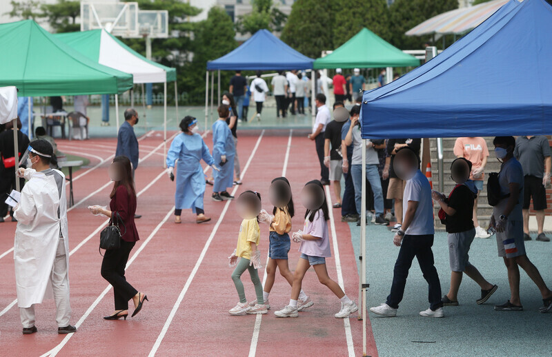 People wait in line to get tested for COVID-19 at a temporary screening center in Incheon on July 6. (Yonhap News)
