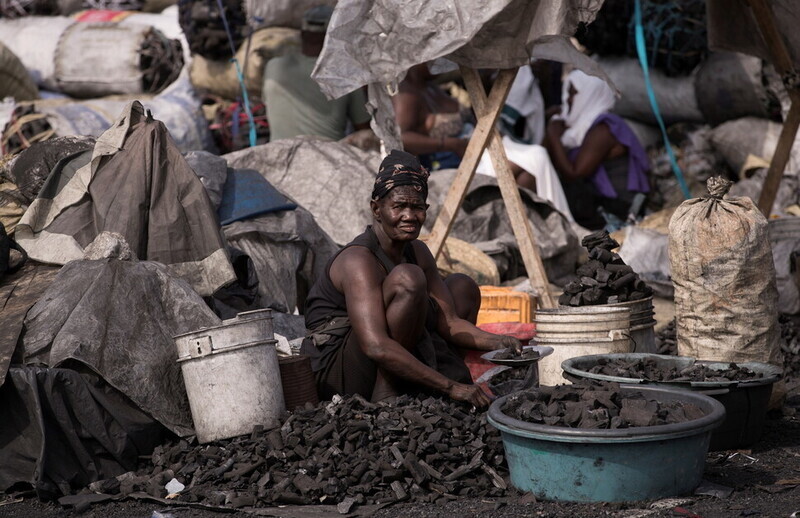 A Haitian woman sells charcoal at a market. (Yonhap News)