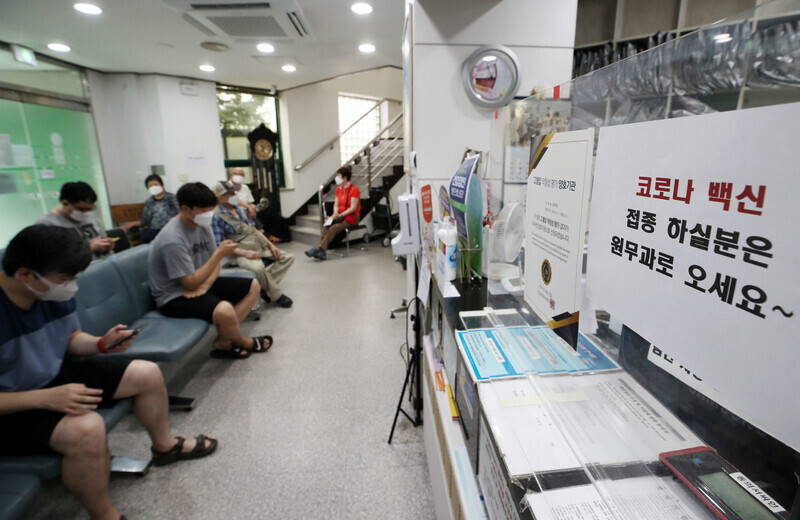 People wait to get vaccinated Thursday at a clinic in Seoul. (Yonhap News)