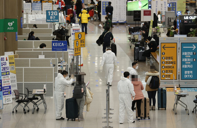 Travelers follow airport quarantine procedures on Feb. 3 after arriving that afternoon at Incheon International Airport’s Terminal 1. (Yonhap News)