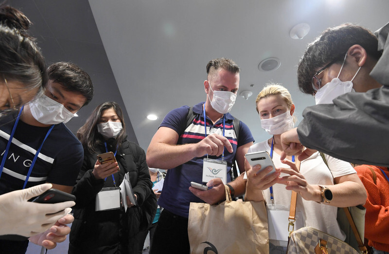 Travelers arriving at Incheon International Airport from Hong Kong download self-diagnosis apps on Feb. 13. (photo pool)