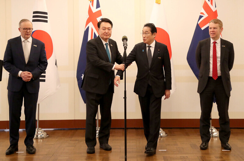 President Yoon Suk-yeol of South Korea (second from left) encourages Prime Minister Fumio Kishida to speak ahead of him following a summit of NATO’s four partners in the Asia-Pacific. On the left is Australian Prime Minister Anthony Albanese, and on the right is New Zealand Prime Minister Chris Hipkins. The meeting took place on the sidelines of the NATO summit in Lithuania on July 12. (Yoon Woon-sik/The Hankyoreh)