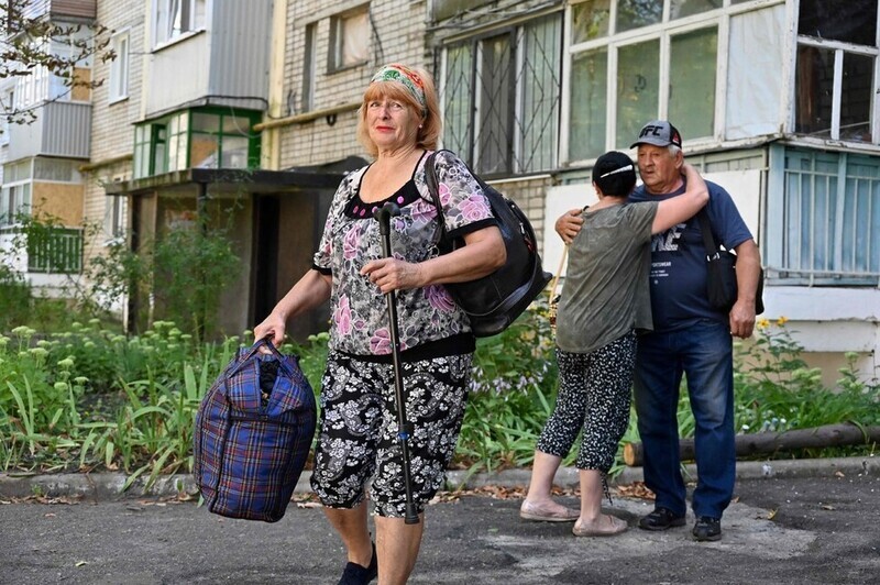 Residents of a village in Kharkiv, Ukraine, evacuate on Aug. 15 amid relentless Russian bombing in the eastern city. (AFP/Yonhap)
