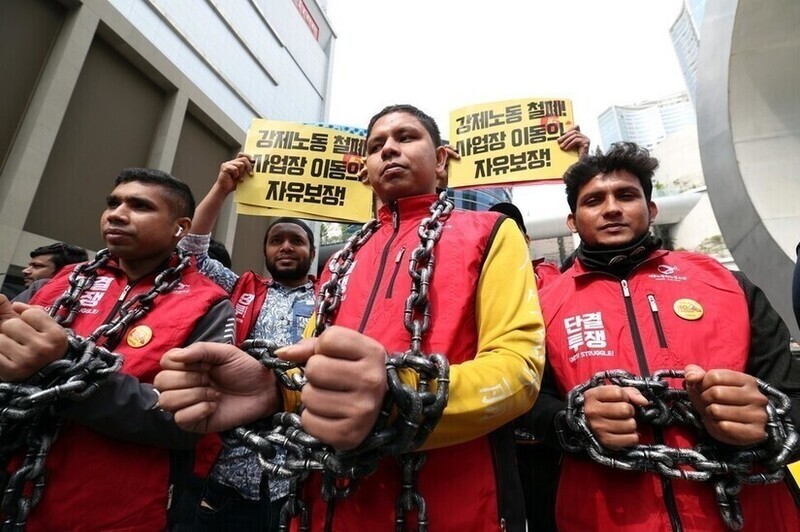 Migrant workers in Korea rally with chains around their hands and necks to symbolize the system that prevents them from freely moving workplaces. (Kang Chang-kwang/The Hankyoreh)