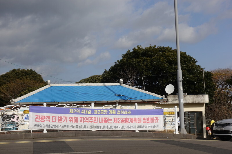 A banner hung up by civic groups opposed to the construction of a second airport on Jeju Island at the airport’s proposed site