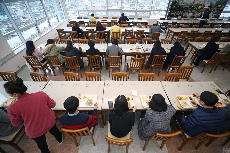 Employees have lunch at the Daegu Metropolitan Office of Education’s in-house cafeteria on Mar. 27, making sure not to sit across from each other and refraining from conversation during their meal. (Yonhap News)