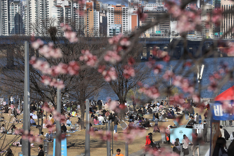 People gather in Seoul’s Yeouido Han River Park on Mar. 22, despite the government’s advisory against large gatherings. (Lee Jeong-a, staff photographer)