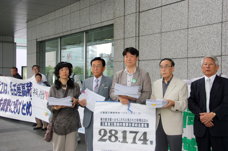 Yamakawa (second right) hands on informational material on forced labor practices during the Japanese colonial occupation in front of Mitsubishi Heavy Industries’ headquarters in Tokyo in 2010.