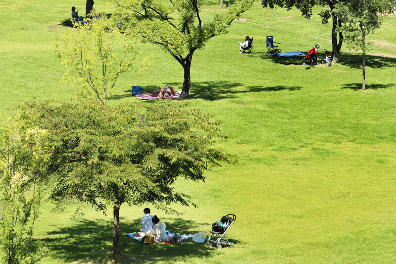 People relax in Seoul’s Yeouido Hangang Park on Sept. 13. Access to many areas of the park has been restricted to limit the spread of COVID-19. (Yonhap News)