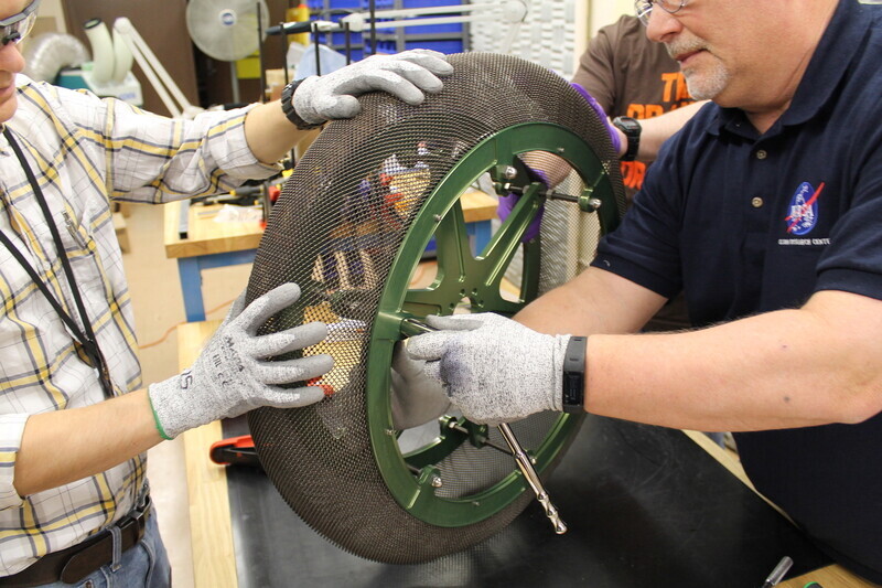 Researchers at the NASA Glenn Research Center build a prototype shape memory alloy tire. (provided by NASA)