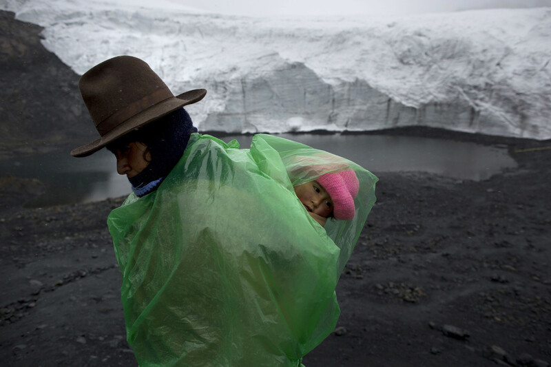 페루 산간지대에서 일하는 빙하 관리인인 파우스타 오티즈(38)가 그의 딸을 업고 걸어가고 있다. 파스토루리빙하는 1980년부터 2014년까지 576m가 녹아 없어졌다. 급격한 빙하의 해빙은 하류 지역의 홍수 위험을 높인다. 후아라즈/AP 연합뉴스