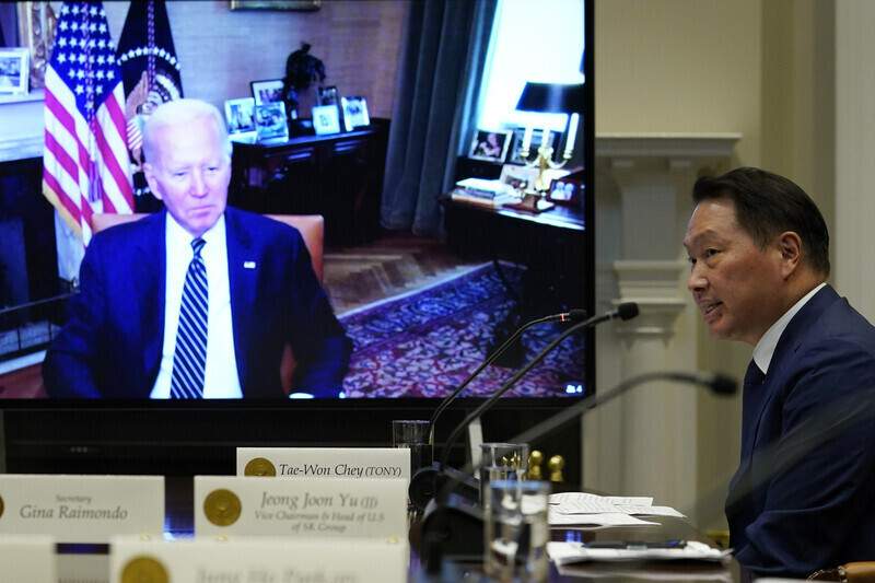 US President Joe Biden (appearing via video conference on the screen on the left) speaks with SK Group Chairperson Chey Tae-won during Chey’s visit to the White House on July 26. (Reuters/Yonhap News)