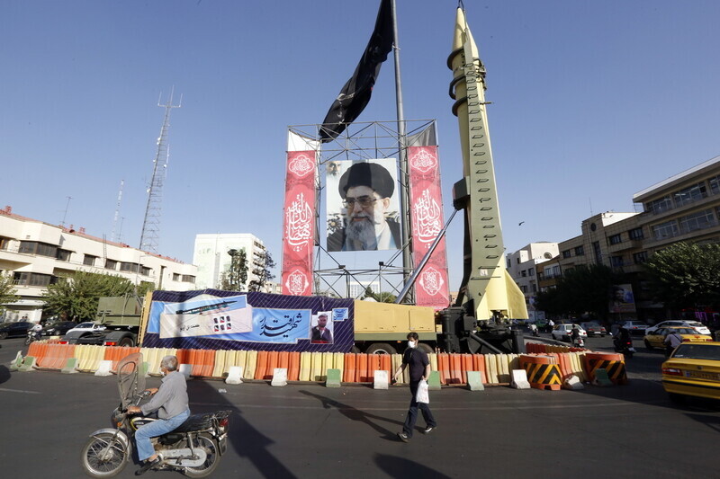 Iranians pass by a roadside installation of a photo of Iranian Supreme Leader Ayatollah Ali Khamenei and a mock missile in Tehran, Iran, Sept. 25. (EPA/Yonhap)